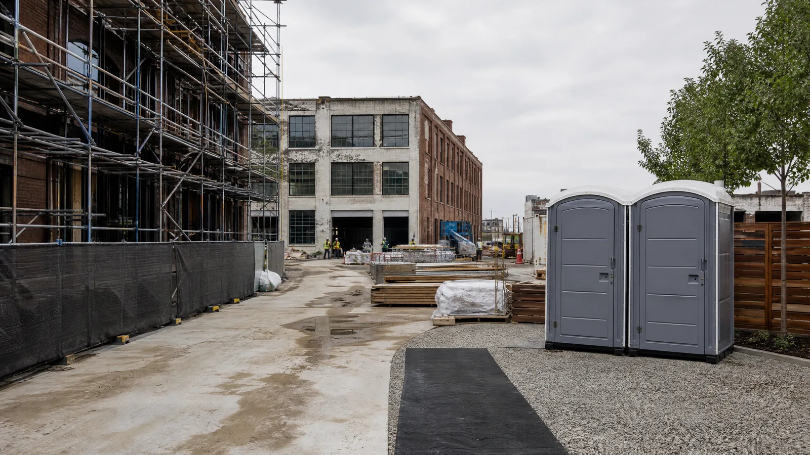 Portable restrooms placed in an orderly commercial renovation service area.